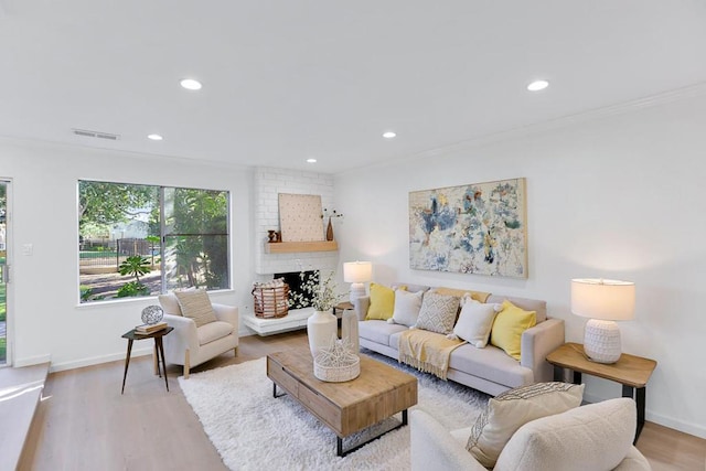 living room featuring a fireplace, ornamental molding, and hardwood / wood-style flooring