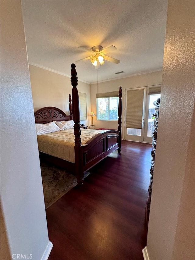 bedroom featuring ceiling fan, dark wood-type flooring, crown molding, and a textured ceiling