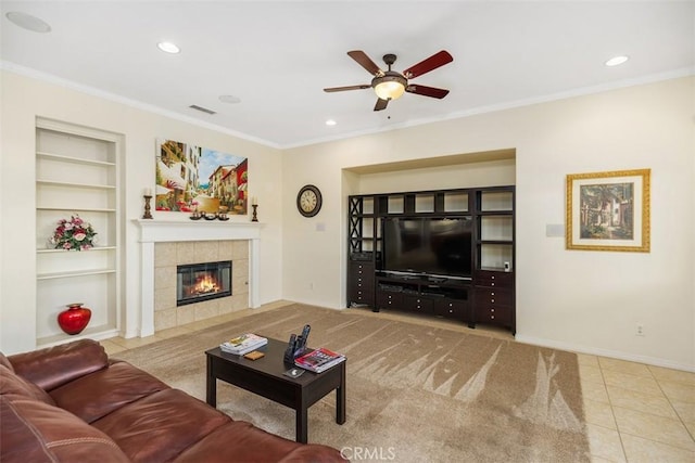 tiled living room featuring a fireplace, built in features, ceiling fan, and crown molding