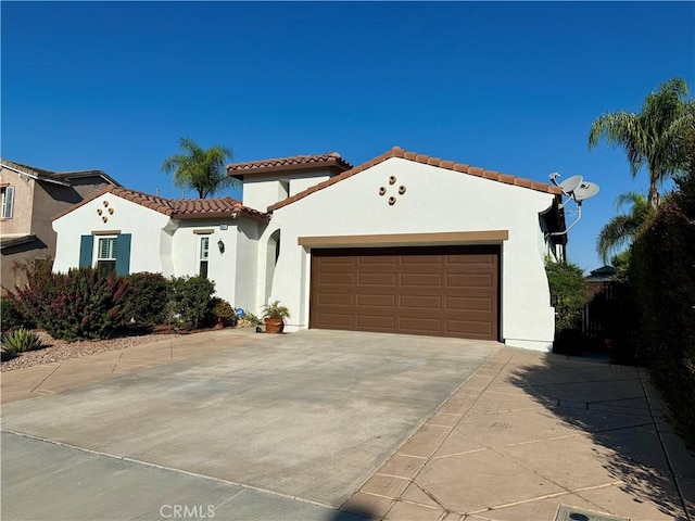 mediterranean / spanish-style house with a garage