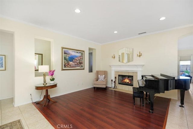 sitting room with a fireplace, tile patterned flooring, and ornamental molding