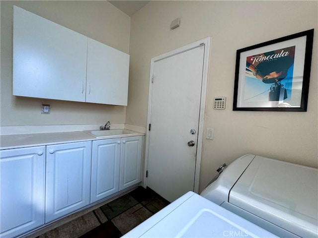 laundry area with cabinets, separate washer and dryer, and sink