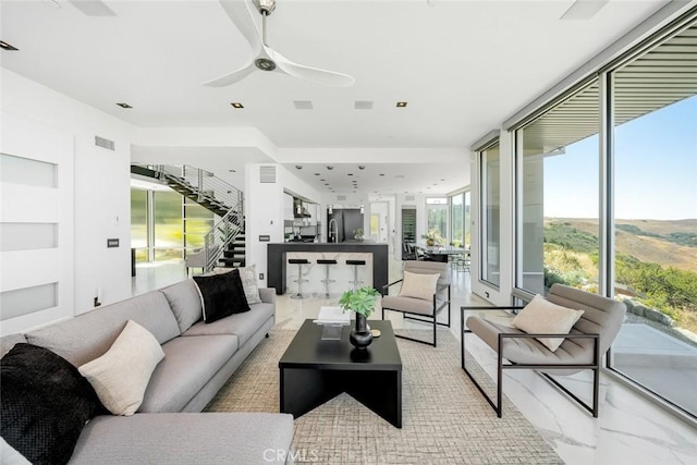 living room featuring ceiling fan and floor to ceiling windows