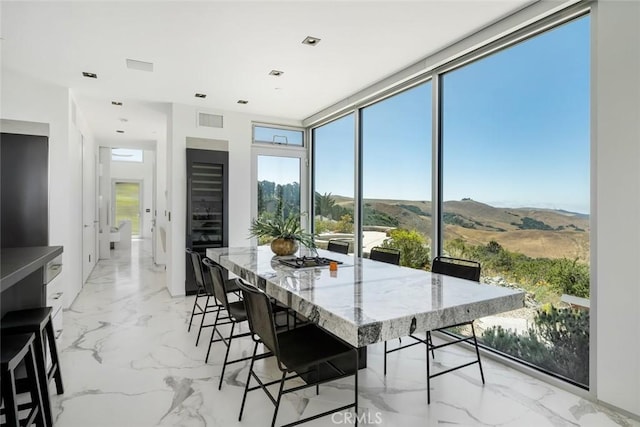 dining area featuring a wall of windows and a mountain view