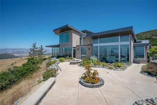 rear view of property featuring a patio area and a mountain view