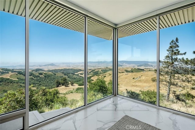 unfurnished sunroom featuring a mountain view