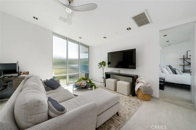 living room with ceiling fan and a wall of windows