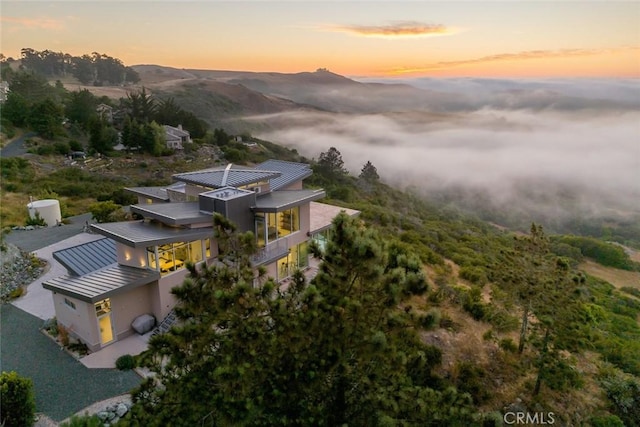 aerial view at dusk featuring a mountain view