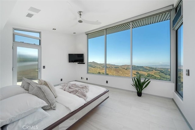 bedroom with ceiling fan and multiple windows