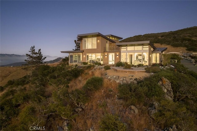 back house at dusk with a mountain view