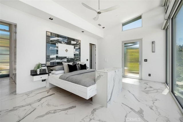 bedroom featuring ceiling fan, access to exterior, and a towering ceiling