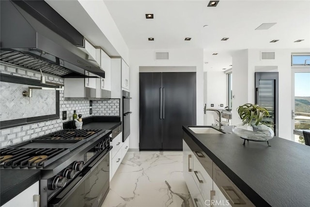 kitchen featuring black appliances, white cabinetry, wall chimney range hood, tasteful backsplash, and sink