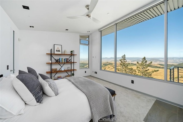 bedroom with ceiling fan and a mountain view