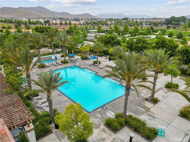 view of pool with a patio and a mountain view