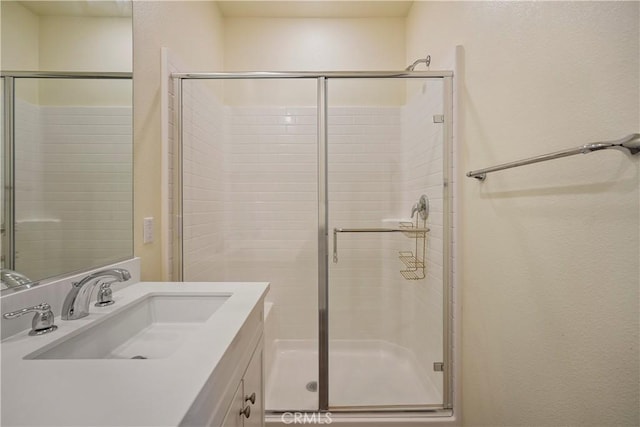 bathroom with a shower with door and vanity