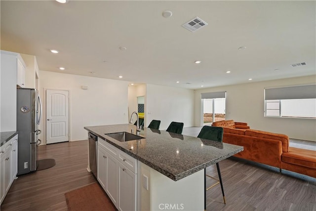 kitchen with sink, stainless steel appliances, white cabinets, and a kitchen island with sink