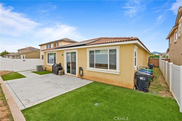 rear view of house featuring a yard, a patio area, and central AC