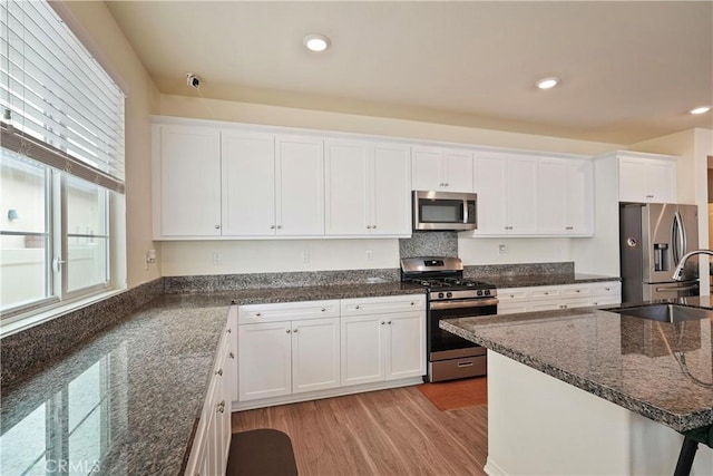 kitchen with stainless steel appliances, white cabinets, and sink