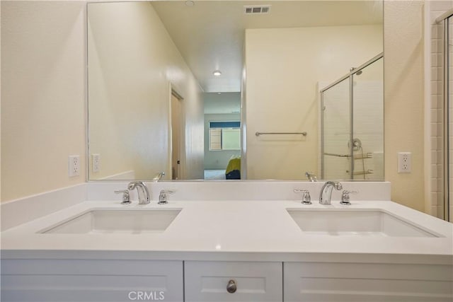 bathroom with a shower with door and vanity