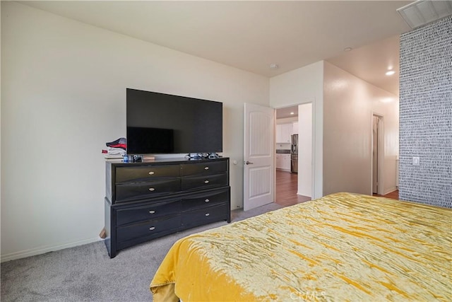 bedroom with carpet floors and stainless steel fridge with ice dispenser