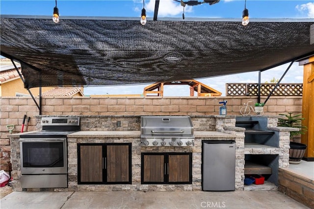 view of patio featuring exterior kitchen and a grill