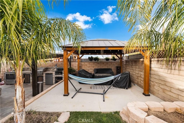 view of patio / terrace featuring exterior kitchen, a gazebo, and a grill