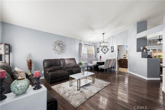 living room featuring dark wood-type flooring, a chandelier, and vaulted ceiling