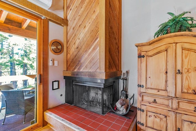 interior details featuring a wall unit AC and a tile fireplace