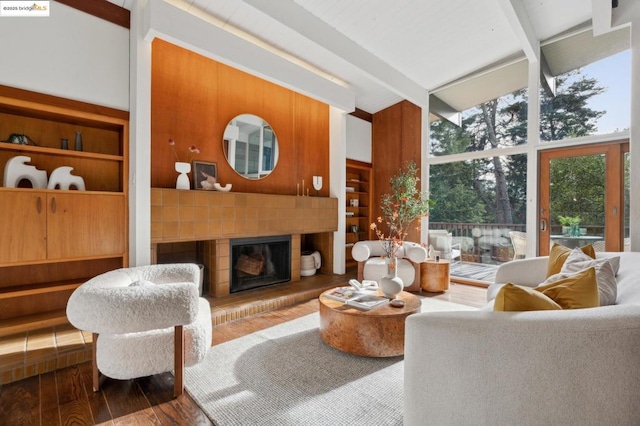 living room with floor to ceiling windows, a high ceiling, beam ceiling, built in features, and wood-type flooring