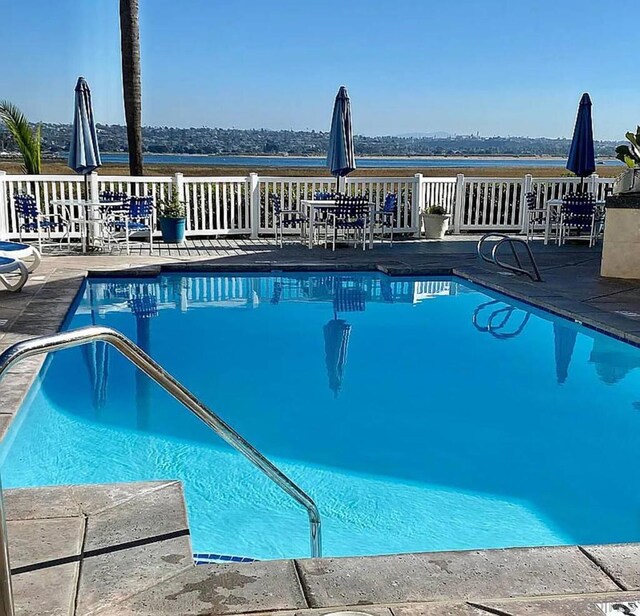 view of swimming pool featuring a water view