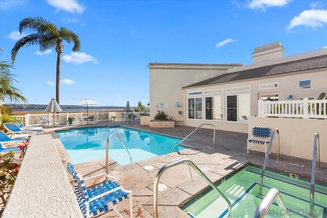 view of pool with an in ground hot tub and a patio