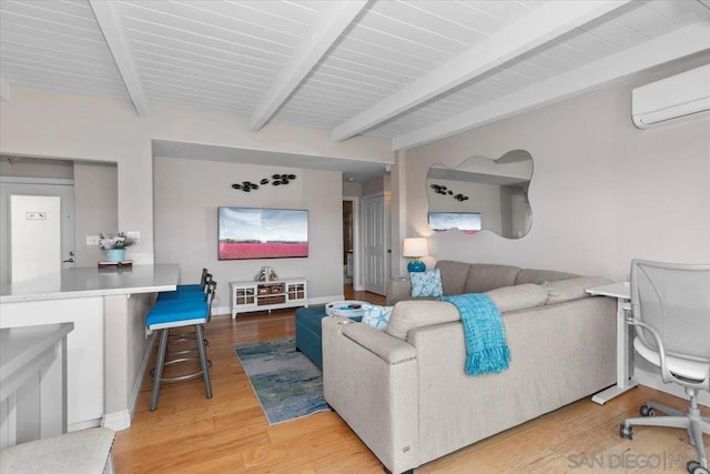 living room featuring an AC wall unit, beam ceiling, and wood-type flooring