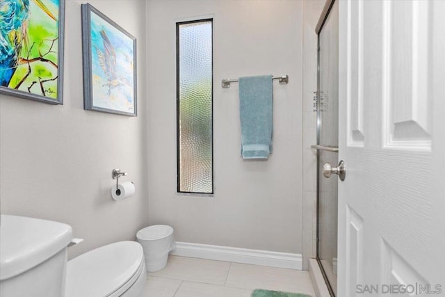 bathroom featuring a shower with shower door, tile patterned floors, and toilet