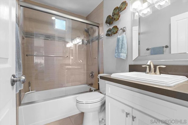 full bathroom featuring tile patterned flooring, bath / shower combo with glass door, vanity, and toilet