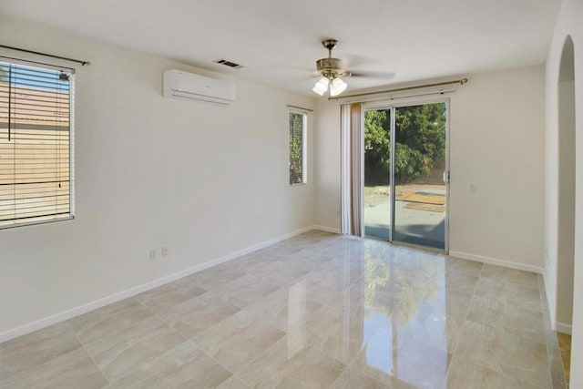 empty room featuring ceiling fan, plenty of natural light, and a wall mounted AC