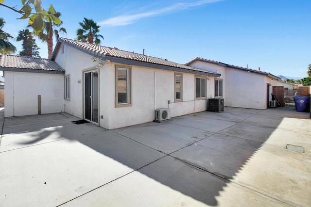 back of property with central AC and a patio area