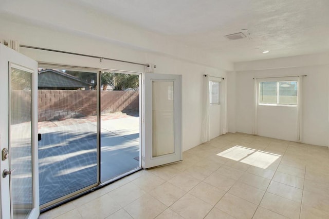 unfurnished room featuring light tile patterned flooring and plenty of natural light