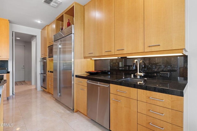 kitchen with sink, appliances with stainless steel finishes, light tile patterned flooring, and decorative backsplash