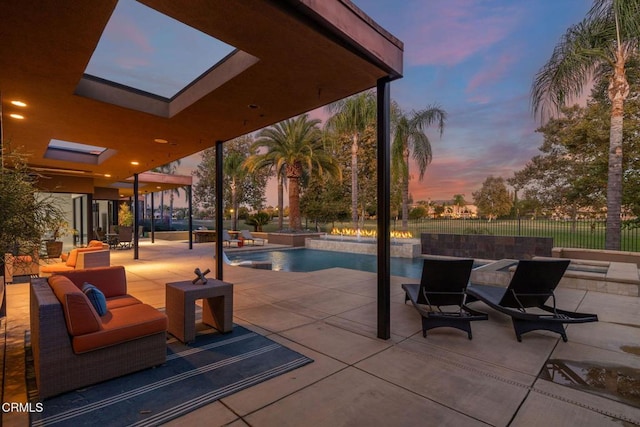 patio terrace at dusk featuring a fenced in pool and an outdoor living space