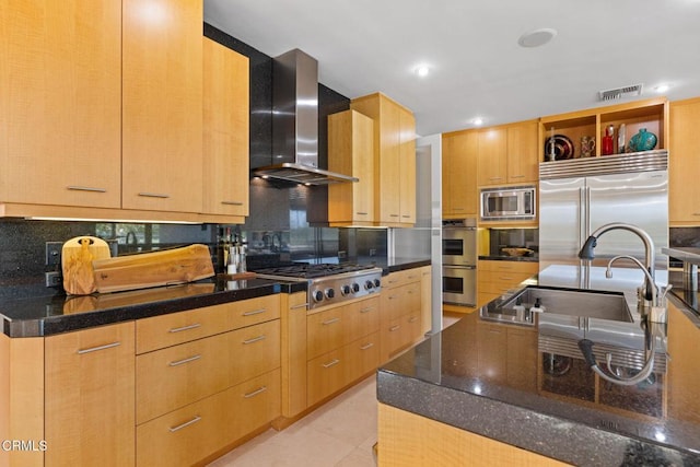 kitchen with built in appliances, an island with sink, wall chimney range hood, tasteful backsplash, and sink