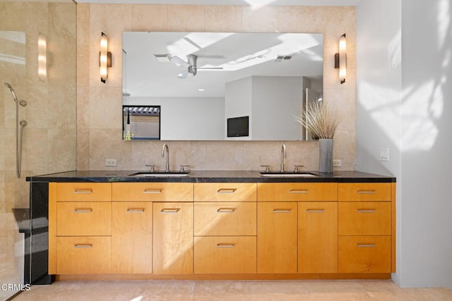 bathroom featuring vanity, decorative backsplash, ceiling fan, and walk in shower