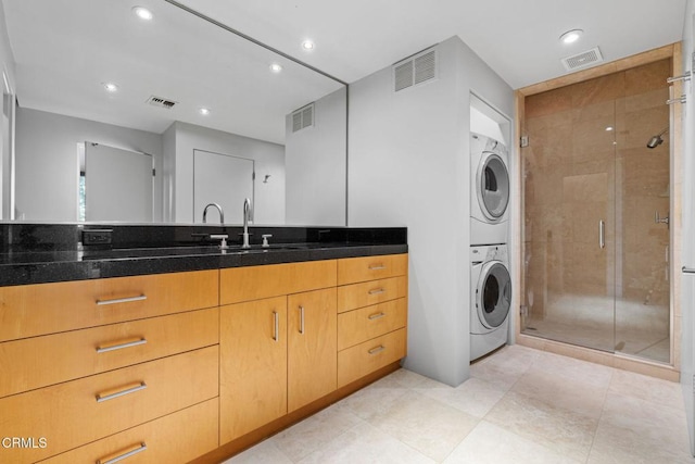 clothes washing area with sink and stacked washer / drying machine