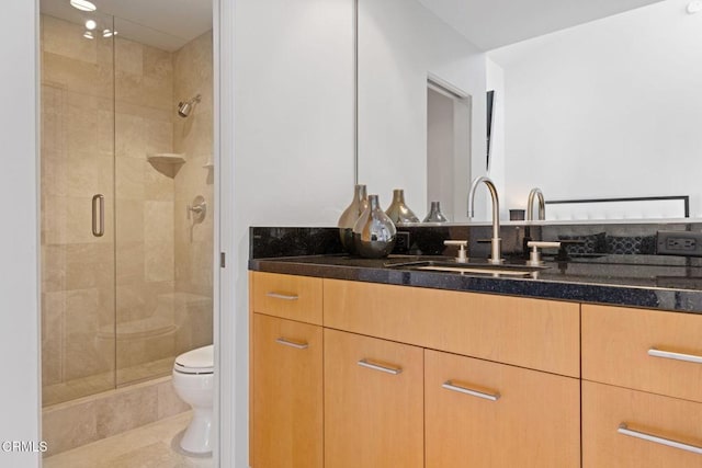 bathroom featuring toilet, tile patterned floors, a shower with shower door, and vanity