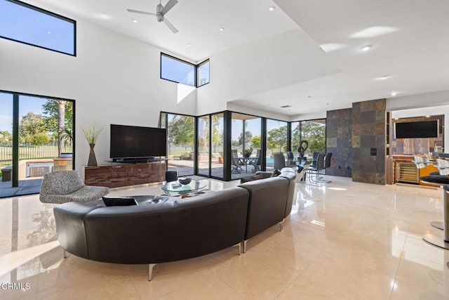 living room with a towering ceiling and ceiling fan