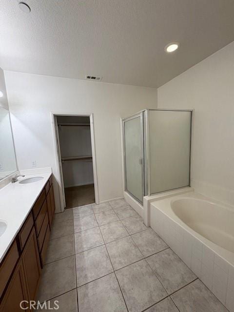 bathroom featuring a textured ceiling, tile patterned floors, independent shower and bath, and vanity