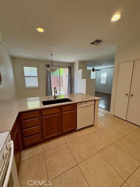 kitchen with white appliances, hanging light fixtures, light tile patterned floors, ceiling fan, and sink