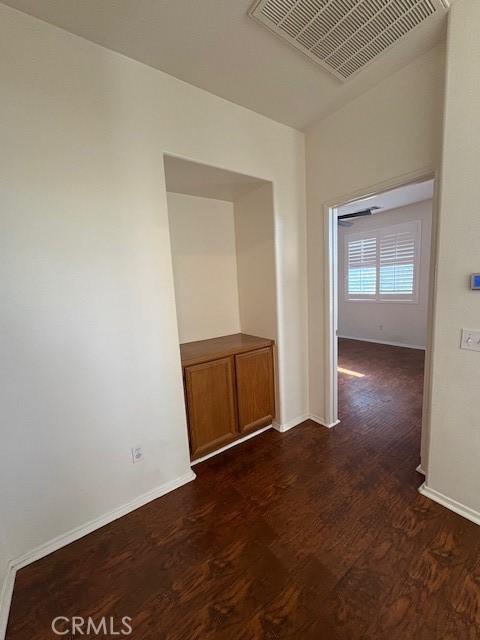 unfurnished room with dark wood-type flooring