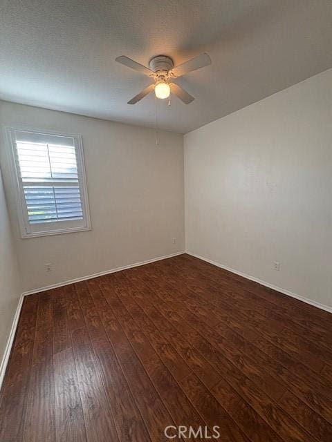 spare room with ceiling fan and dark hardwood / wood-style flooring