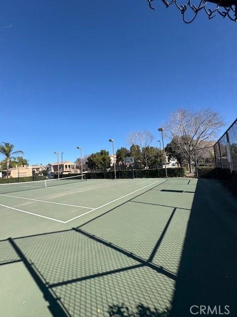 view of tennis court with basketball hoop