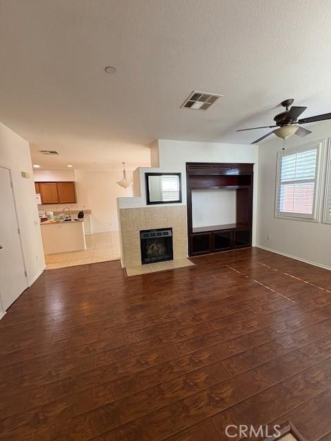 unfurnished living room featuring ceiling fan and dark hardwood / wood-style floors